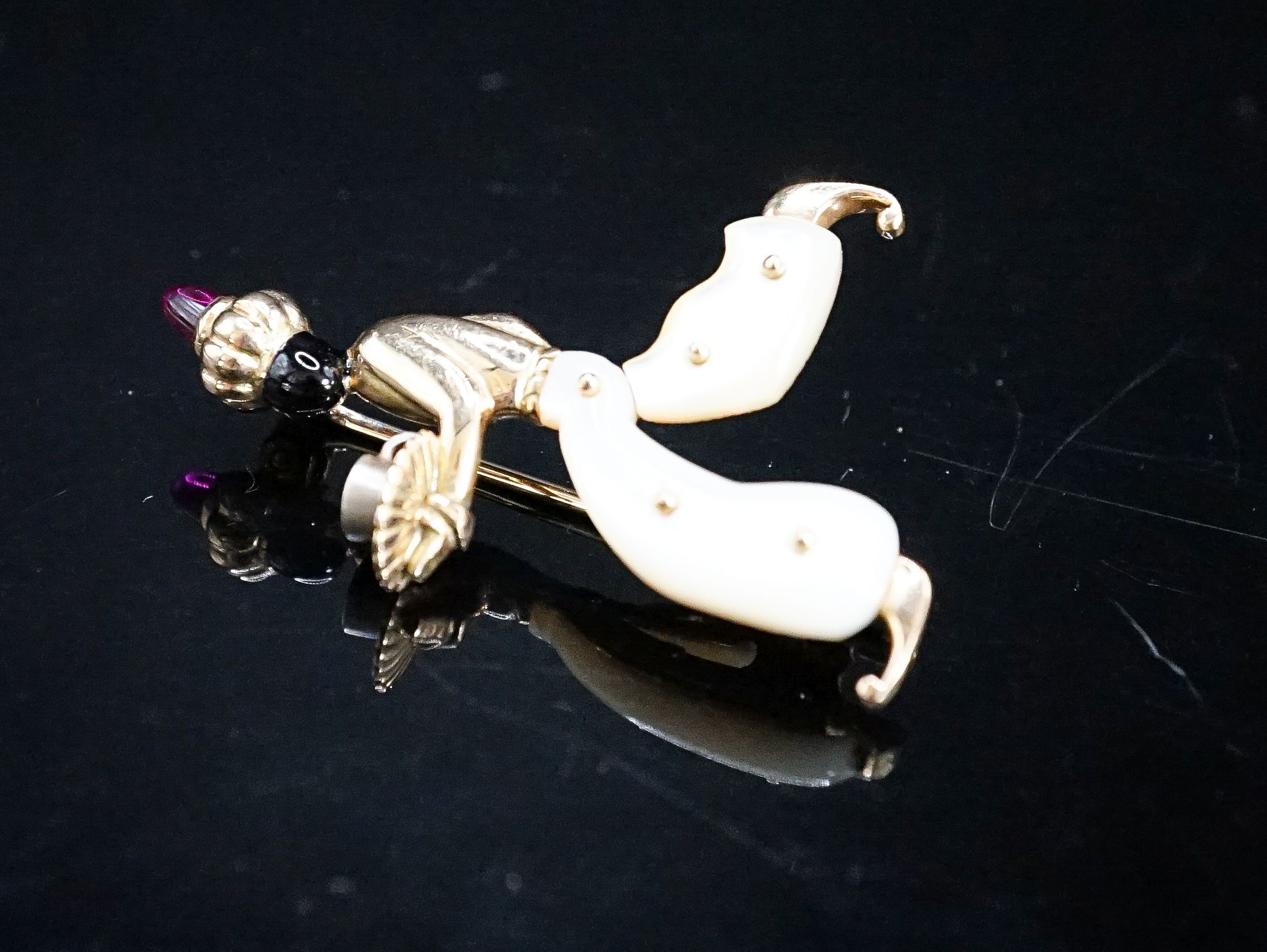 A 20th century Viennese 585 yellow metal, black enamel, mother of pearl and cabochon set brooch, modelled as a Blackamoor, 41mm, gross weight 7.2 grams.